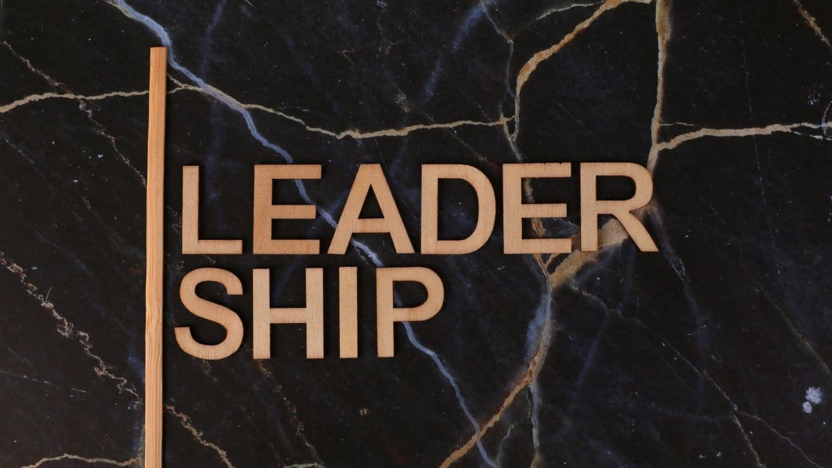 Wooden letters spelling 'Leadership' on a dark marble surface, symbolizing strength and elegance.