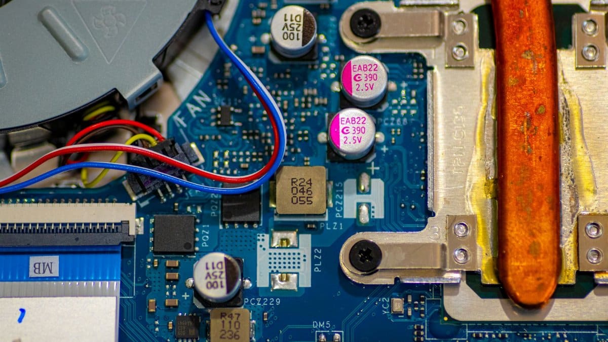 Detailed image showing circuitry and components on a computer motherboard with wires and capacitors.