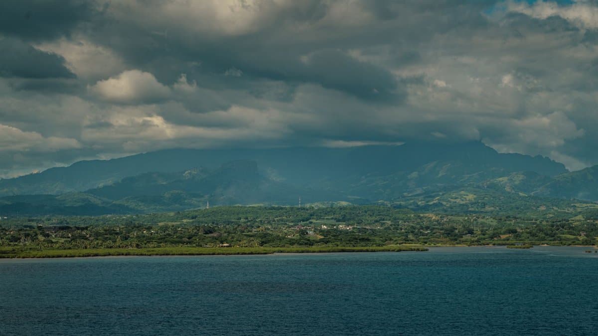 Explore the stunning landscape of Suva with lush mountains and the Pacific Ocean under a cloudy sky.