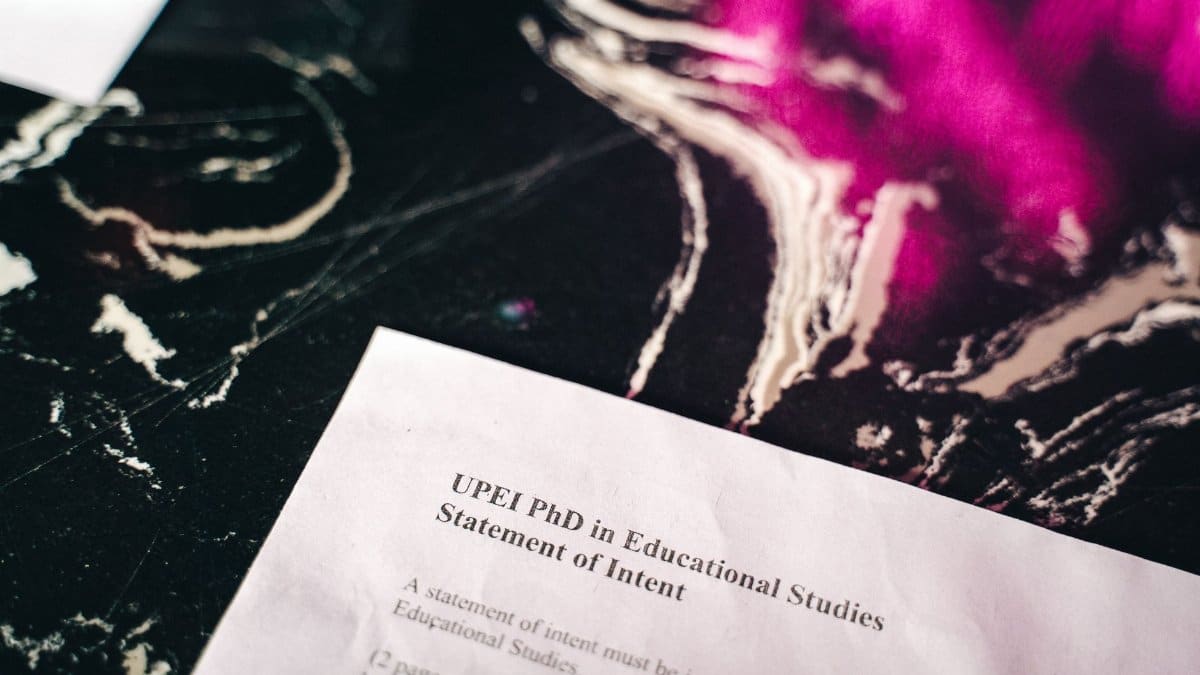 Close-up of a statement of intent document on a marbled surface with bright pink reflections.