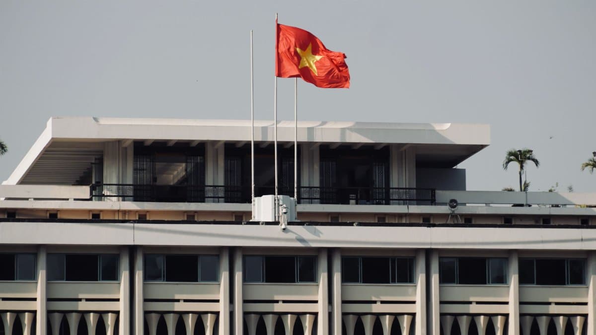 Independence Palace in Ho Chi Minh City with the Vietnamese flag prominently displayed.