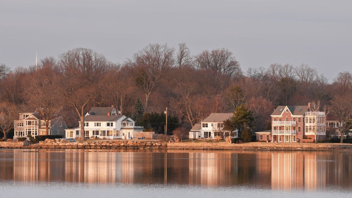 Beautiful waterfront homes in Stamford, Connecticut at twilight reflecting over calm water.