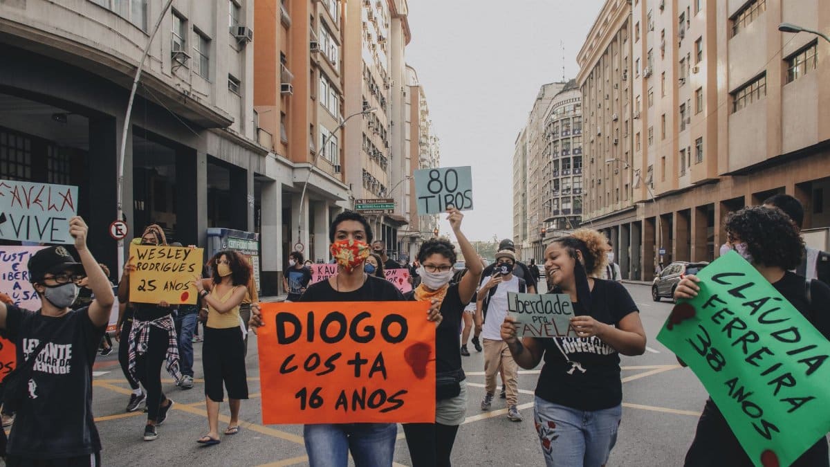 A group protest on Rio streets advocating for justice and equality.