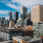 Aerial view of downtown Seattle's skyline featuring iconic skyscrapers under a bright blue sky.