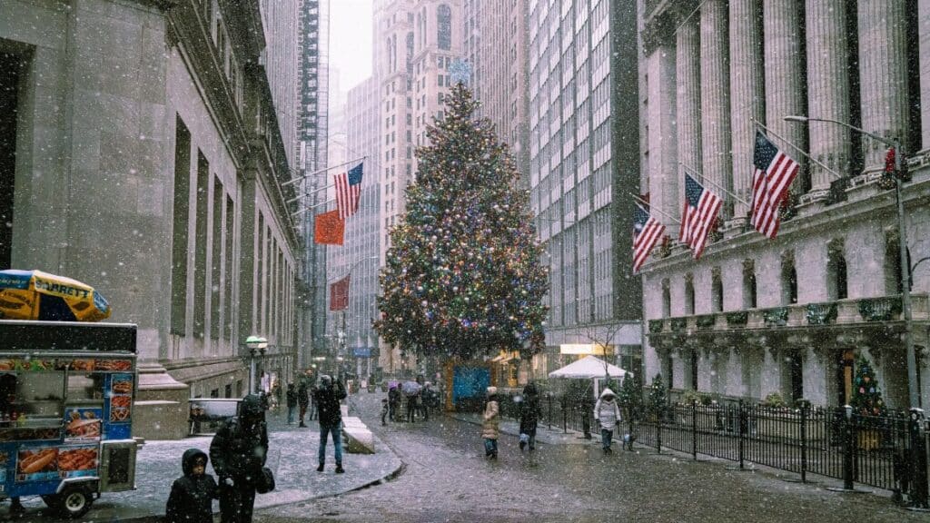 A snowy winter scene in New York City with a decorated Christmas tree and bustling street life.