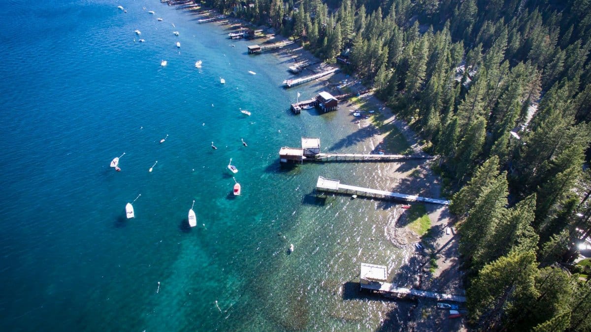 Stunning aerial shot of Lake Tahoe's forested shoreline and boats during summer.