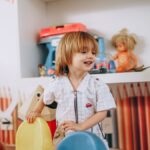 Smiling child enjoys playtime in a vibrant, creative preschool classroom environment.
