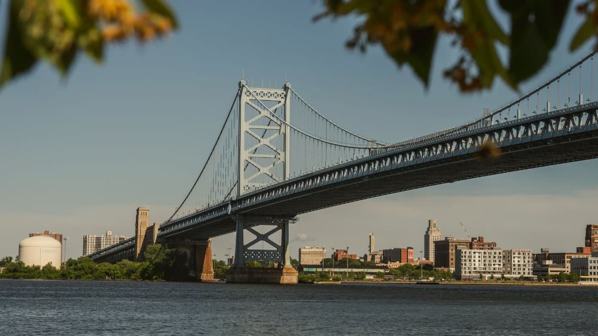 Scenic view of Ben Franklin Bridge spanning the Delaware River with Philadelphia skyline in summer.