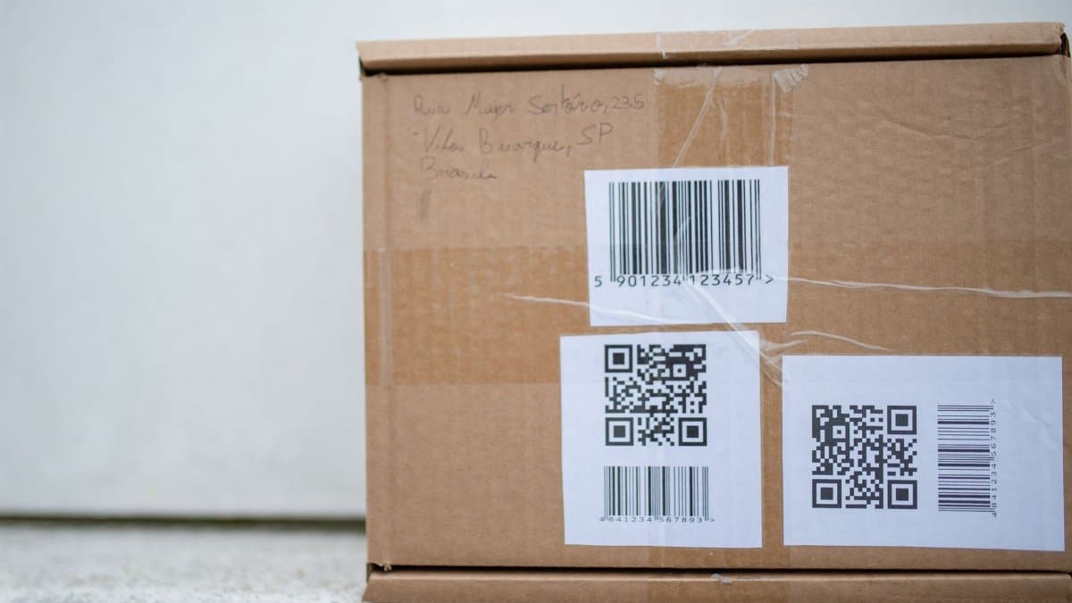 Close-up of a cardboard package with QR codes and a barcode, ideal for delivery and shipping concepts.