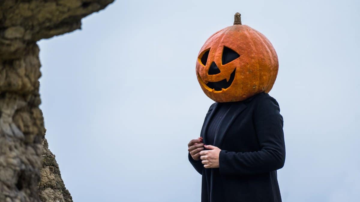 Person with pumpkin head in Guasca, Colombia showcasing Halloween vibe outdoors.