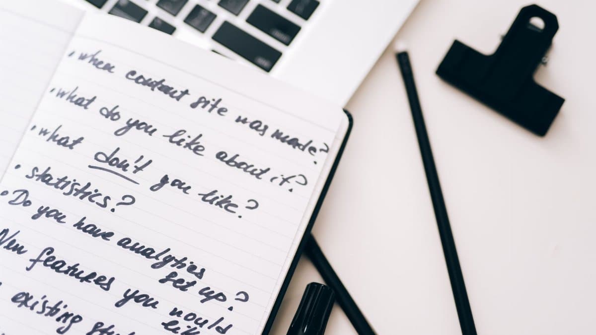 A close-up view of a notebook with handwritten notes alongside a laptop for planning and strategy.