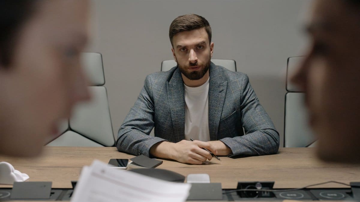 Serious businessmen engaged in a formal meeting around a conference table.