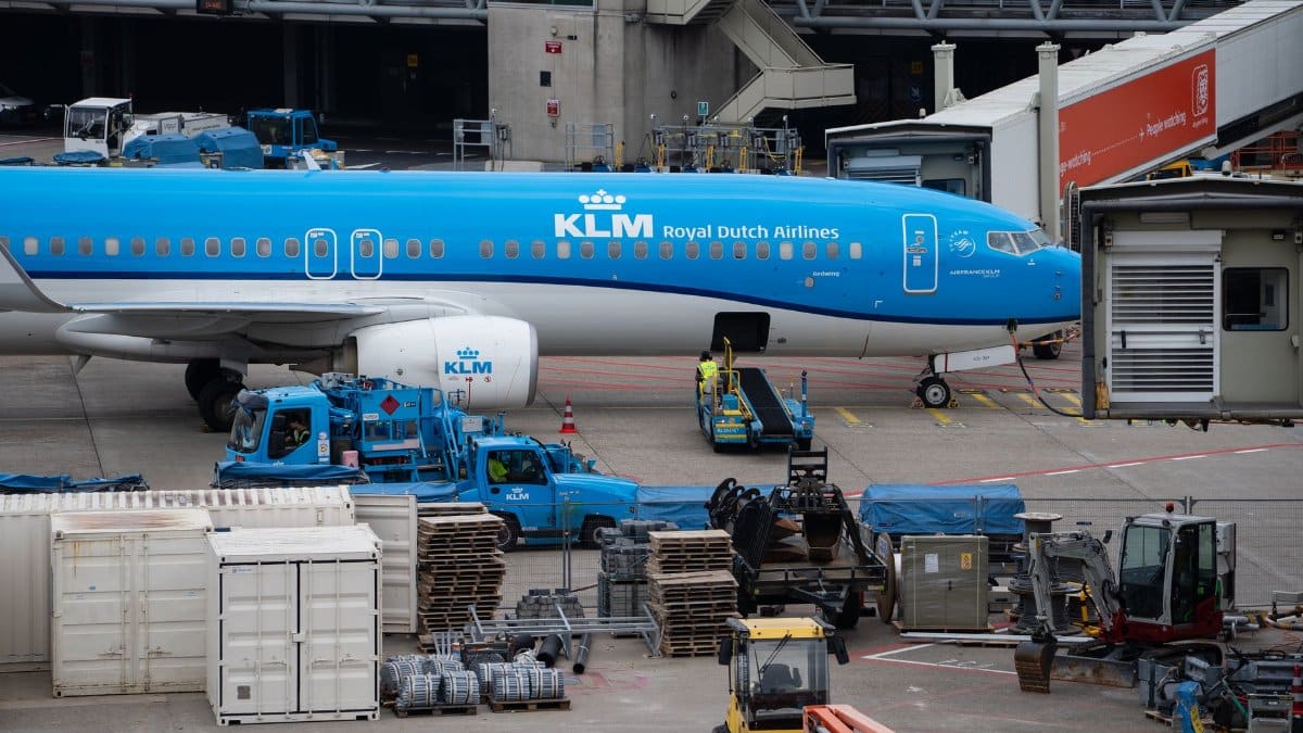 KLM Royal Dutch Airlines airplane docked at a busy airport terminal.