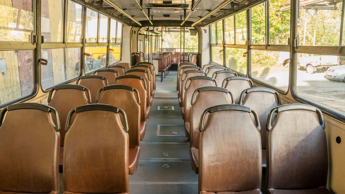 Interior view of an empty vintage bus in Wrocław, Poland, showcasing rows of brown seats.