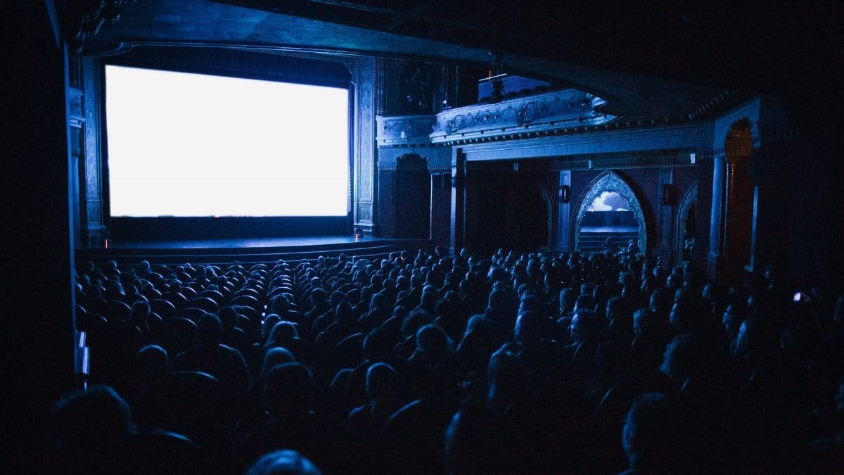 A full cinema theater in Budapest with an audience watching a movie at night.