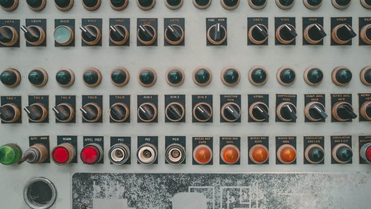 Close-up of a vintage industrial control panel with multiple buttons and switches.