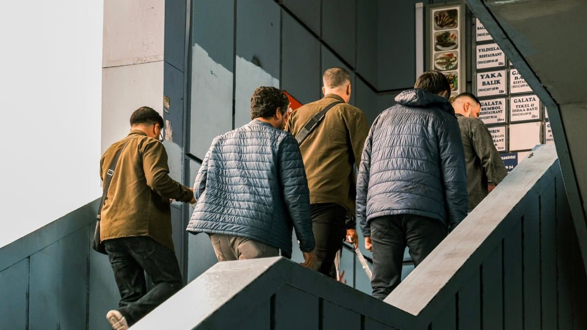 A group of men ascend a blue staircase in Istanbul, showcasing urban lifestyle.