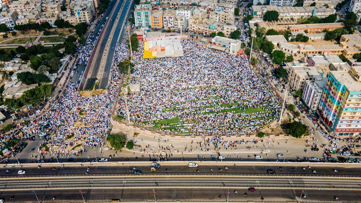 High-angle view of a large outdoor gathering in a city, showcasing crowd density and urban architecture.