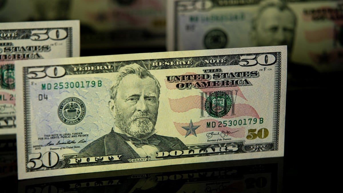 Detailed close-up of a US fifty dollar bill, emphasizing currency design and wealth theme.