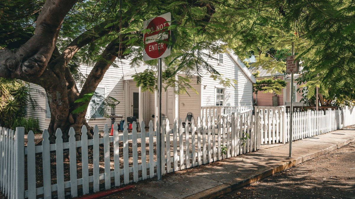 Beautiful house with a white picket fence and lush greenery in Key West, Florida.