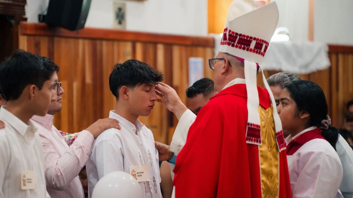 Bishop performing confirmation during a church ceremony with young participants.