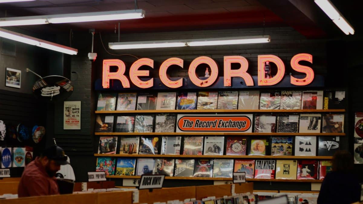 A cozy record store with a vintage vibe, displaying a neon 'Records' sign and assorted vinyl albums.
