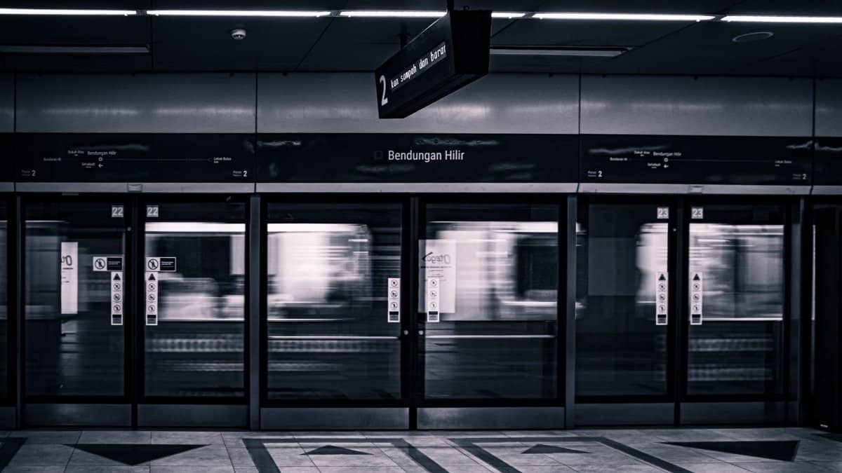 Monochrome image capturing a metro train in motion at Bendungan Hilir station, Jakarta.