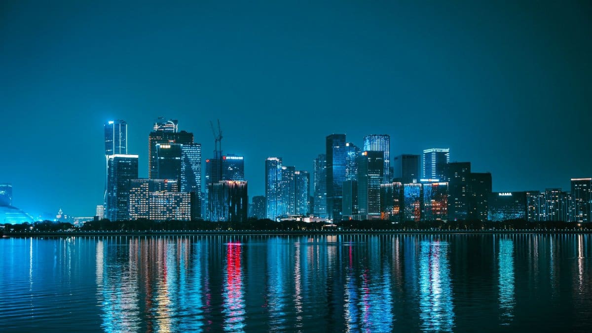 Explore the mesmerizing night skyline of Hangzhou, China, with vibrant reflections on the Qiantang River.