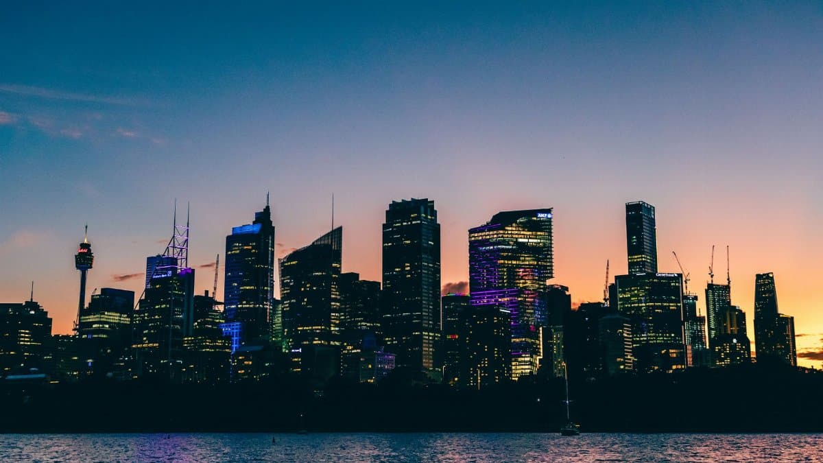Breathtaking view of Sydney's skyline at sunset with vibrant colors reflecting on the water.