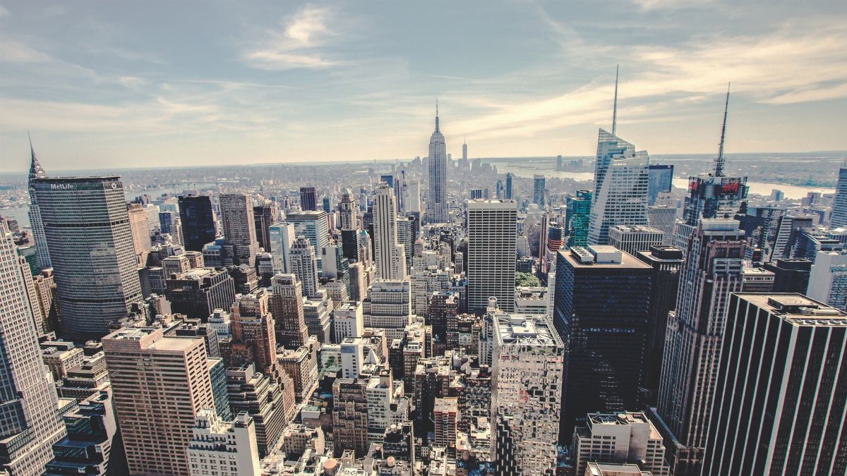 Aerial view of the iconic New York City skyline showcasing skyscrapers under a clear blue sky.