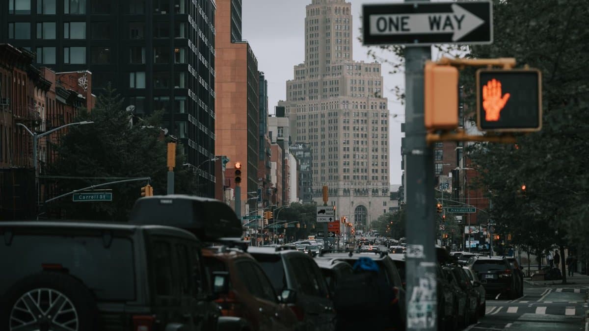 View of a bustling Brooklyn street with cars and iconic skyscraper in New York City.