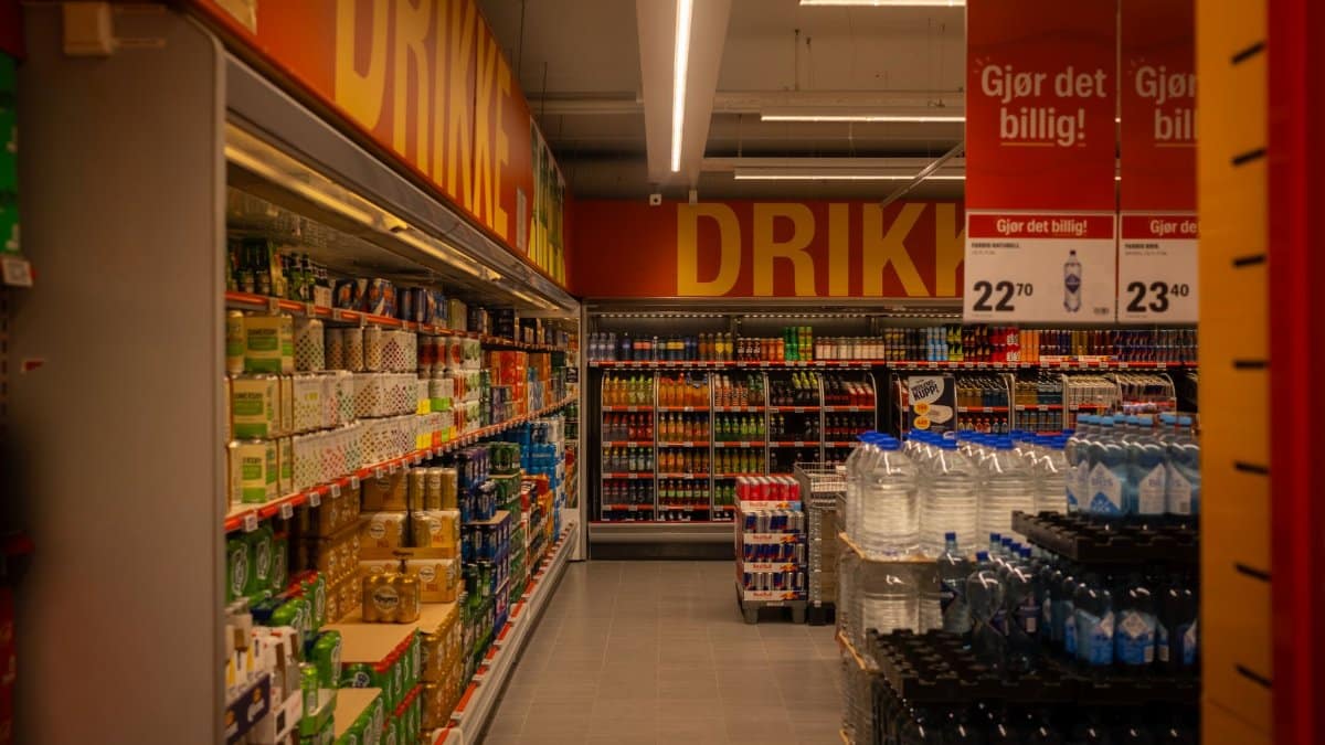 Colorful drink aisle in a supermarket with signage promoting deals.