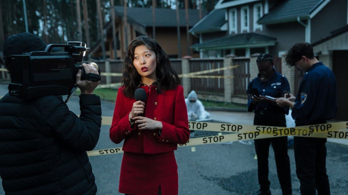 A journalist reporting from a crime scene with police officers and cameraman.