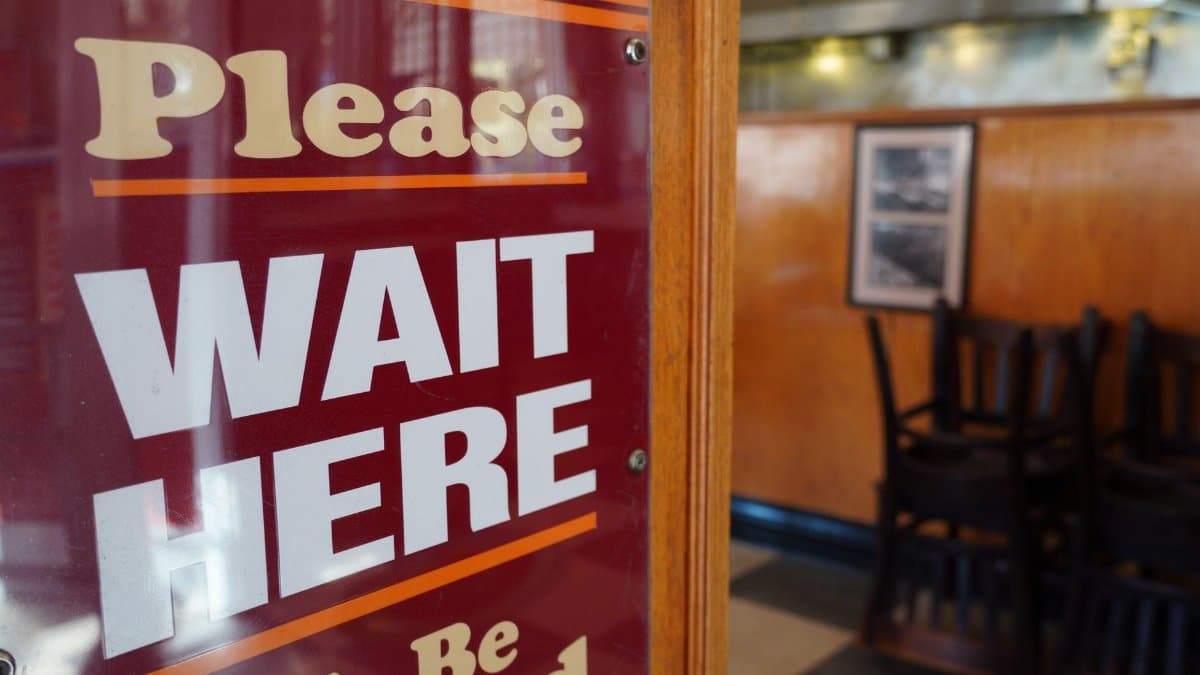 Close-up of 'Please Wait Here' sign inside a Los Angeles diner.