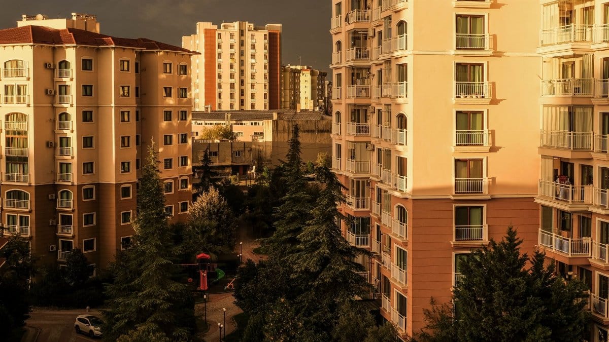 Scenic view of İstanbul apartment buildings at golden hour, featuring trees and cityscape.