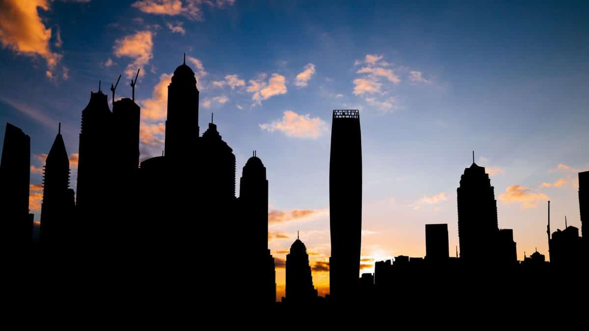 Silhouette of a city skyline against a vibrant sunset sky, showcasing urban architecture and sunset hues.