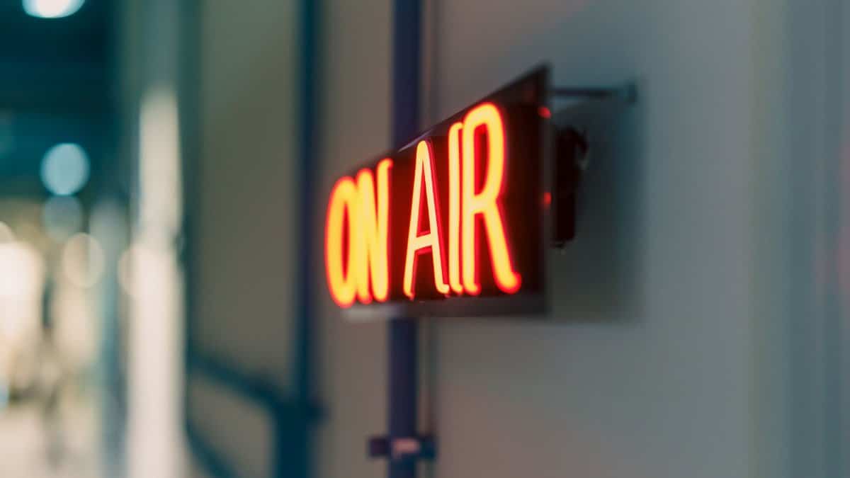 Bright red 'On Air' neon sign captured indoors, ideal for media content.