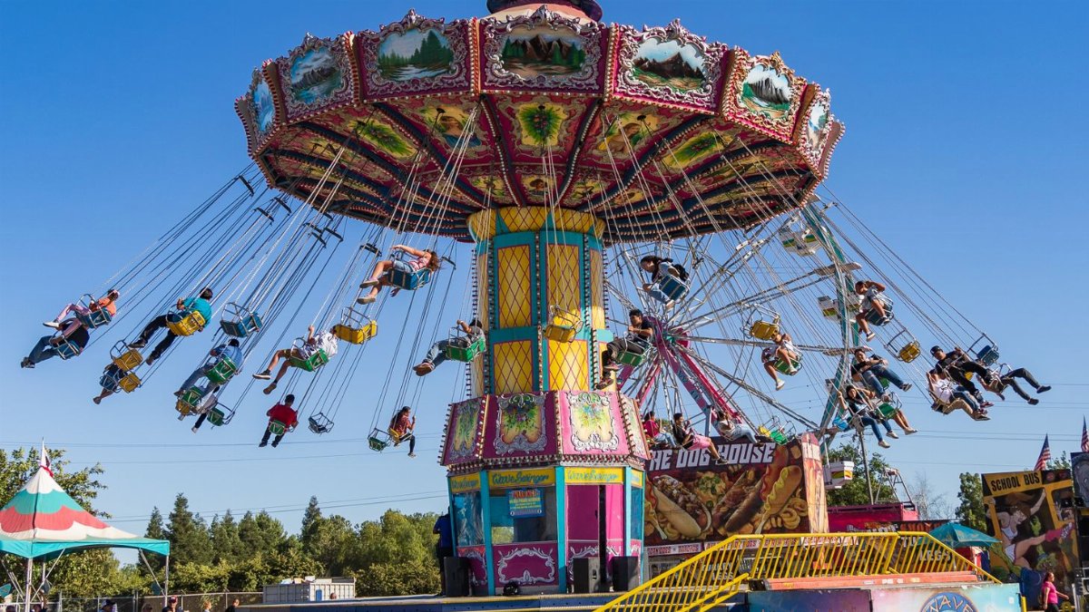 Vibrant carousel ride at Merced County Fair in California on a sunny day, showcasing joyful amusement park fun.