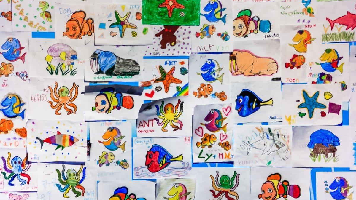 A colorful collage of children's drawings featuring various marine life in vibrant hues.