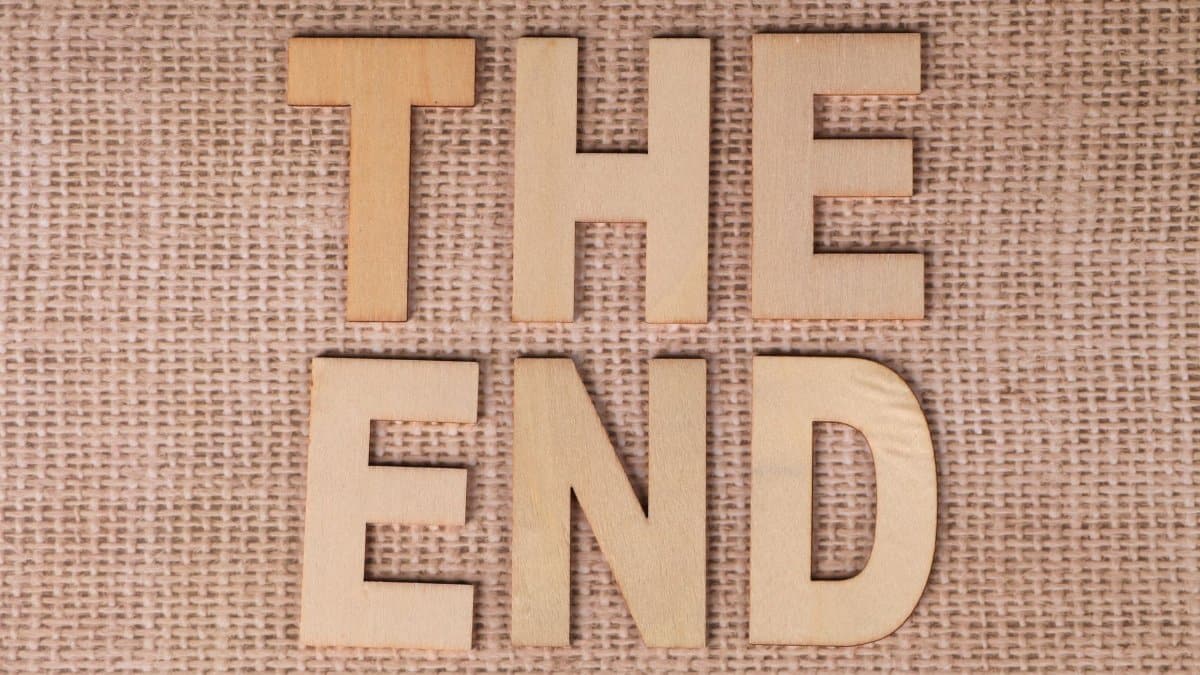 Wooden letters arranged to spell 'The End' on a burlap background.