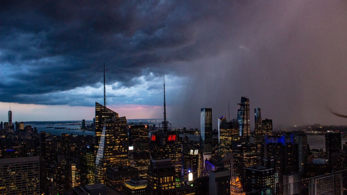 Stunning aerial view of New York City's illuminated skyline under stormy skies.