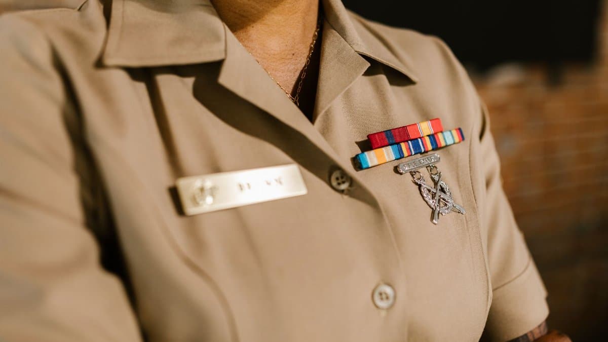 A detailed shot of a military uniform displaying medals and identification badges representing achievement and honor.