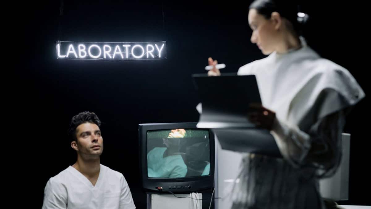 Scientist recording data in a modern laboratory setting with a patient.