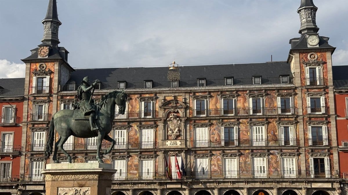 View of Plaza Mayor in Madrid featuring a historic equestrian statue under a bright sky.