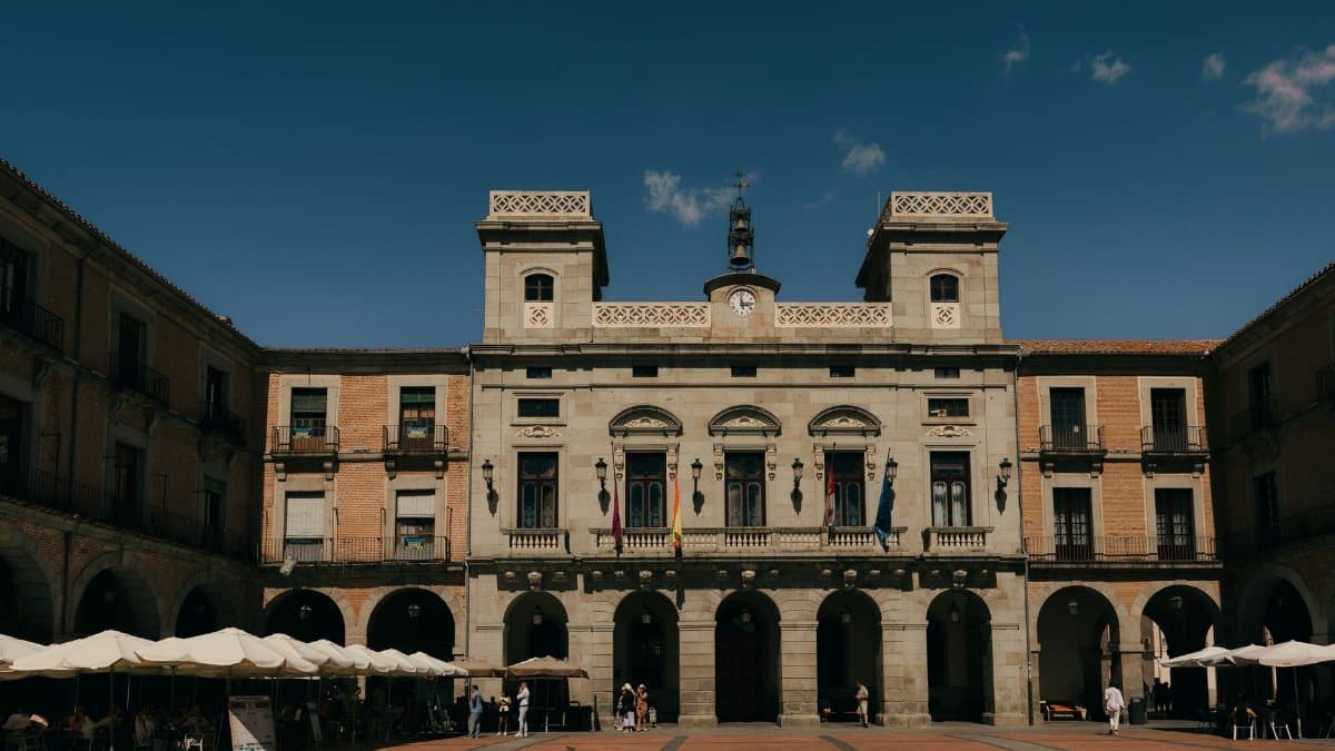 Historic architecture of Plaza Mayor in Ávila, Spain with a clear blue sky.