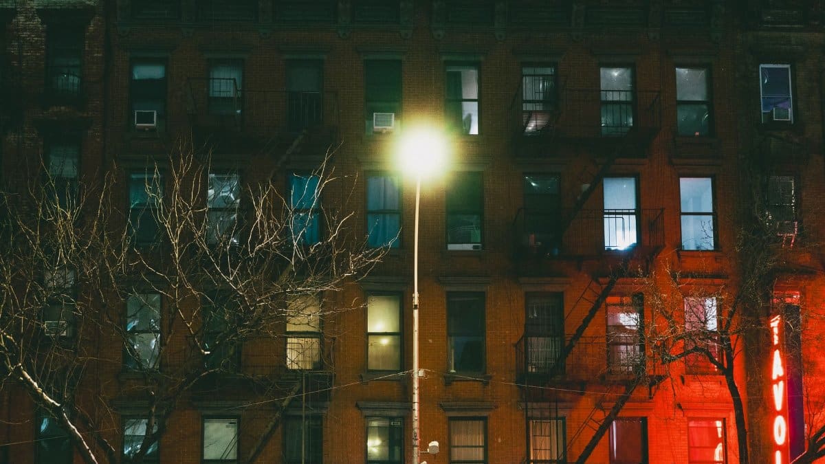 Capture of a dimly lit New York City building facade at night, highlighting urban architecture.