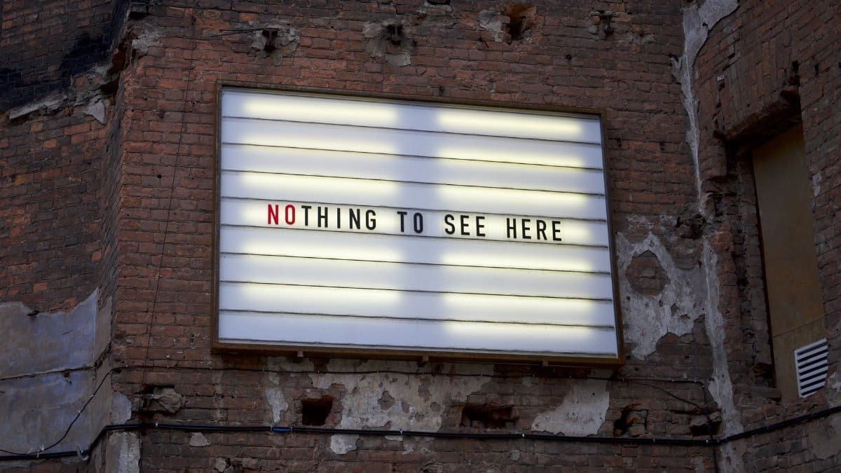 An old marquee on a weathered brick wall displaying the phrase 'Nothing to See Here.'