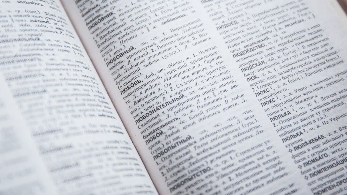 Close-up view of an open Russian dictionary showing detailed text and entries.