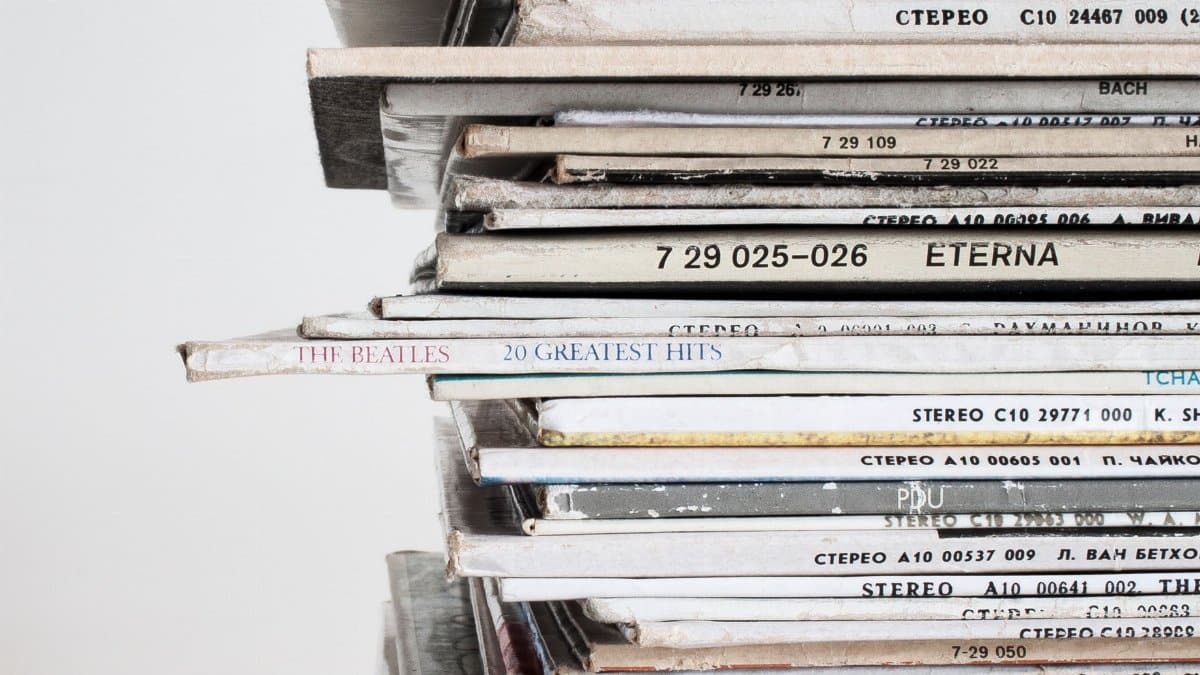 Close-up shot of a stacked pile of vintage vinyl record albums showcasing classic music covers.