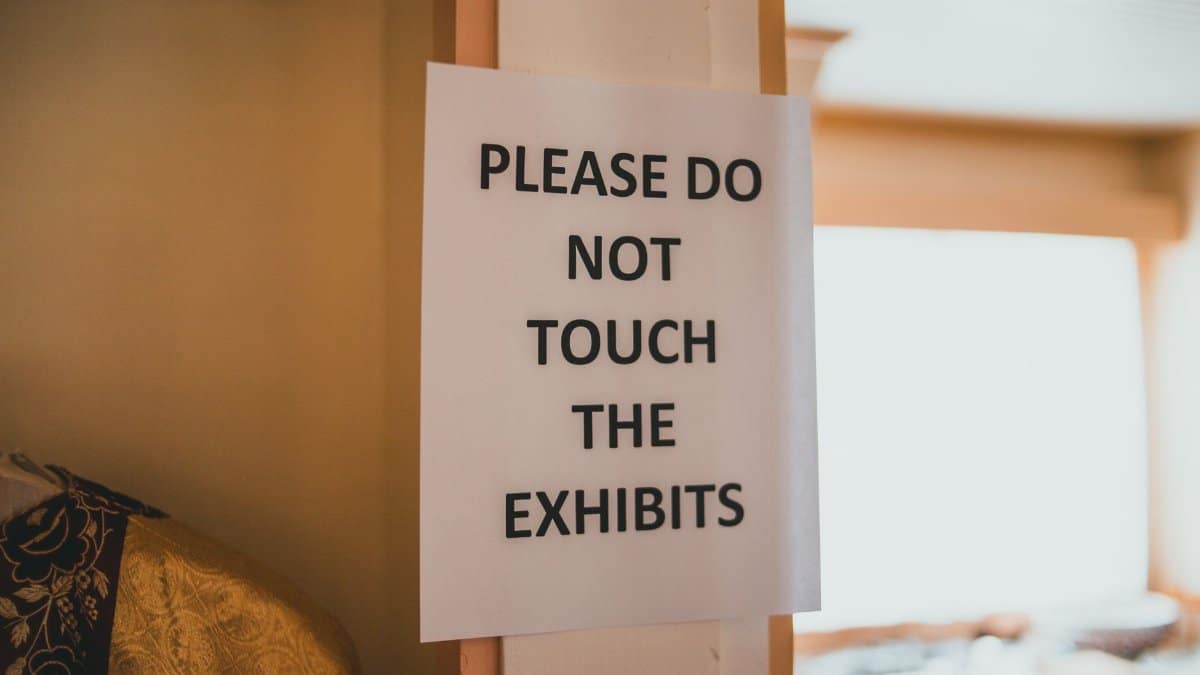 A warning sign in a museum advising visitors not to touch exhibits.